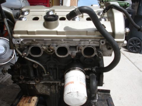 1990 Ford Taurus - Close-up view of an engine assembly, showing the oil filter and various hoses connected to the engine block.