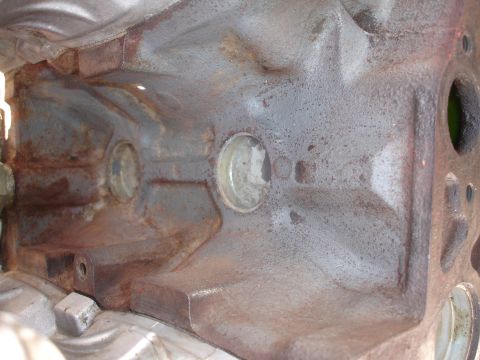 1990 Ford Taurus - Close-up view of the interior of a heavily rusted engine block, showing two cylinder bores and internal casting details.