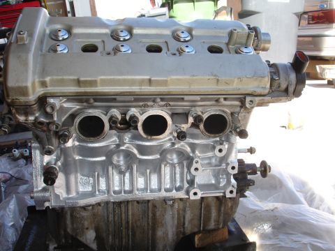 1990 Ford Taurus - Engine block with intake manifold and exhaust ports visible, likely undergoing rebuild or repair.