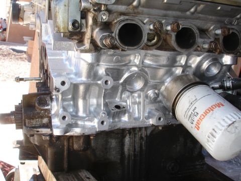 1990 Ford Taurus - Close-up of an engine block with an attached Motorcraft oil filter, showing mechanical components and metallic details.