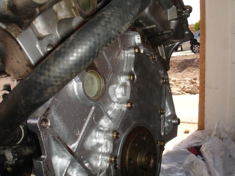 1990 Ford Taurus - Engine block and transmission bell housing detail, with a hose running across the top.