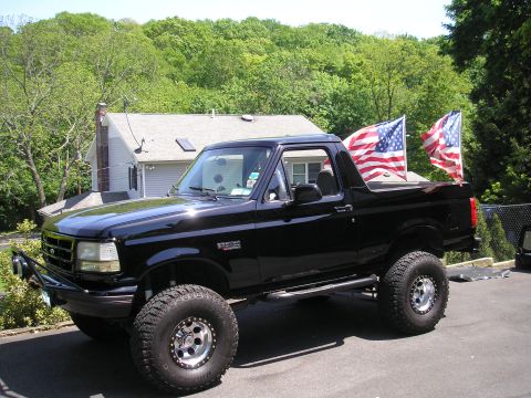 1995 Ford Bronco - Black 1995 Ford Bronco with American flags displayed in the rear.