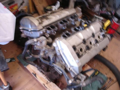1992 Ford Taurus - Engine assembly components are laid out on a wooden surface, possibly for a rebuild or swap.