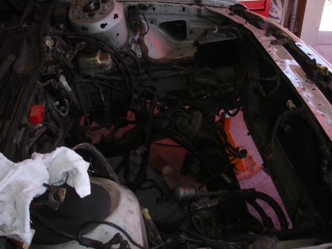 1992 Ford Taurus - The engine bay is exposed, with wiring harnesses and various components visible during a rebuild process.
