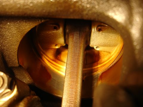1992 Ford Taurus - This image shows a close-up view of an engine's internal components, specifically a piston and connecting rod, lubricated with oil.