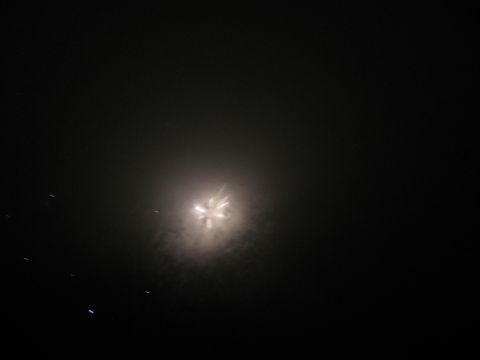1985 Ford LTD Crown Victoria - A bright burst of fireworks illuminates the night sky, creating a hazy glow.