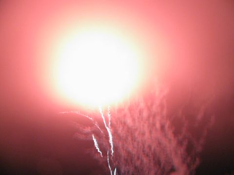 1985 Ford LTD Crown Victoria - A bright explosion of fireworks lights up the night sky with red and white hues.