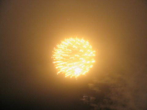 1985 Ford LTD Crown Victoria - A bright yellow firework bursts in the night sky, illuminating the surrounding haze.