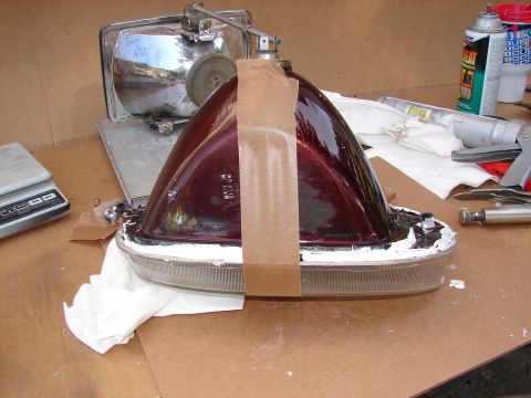 1973 Ford Ranchero - A car headlight assembly, likely for a classic vehicle, is shown disassembled and taped for repair work.