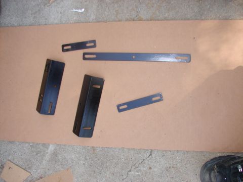 1973 Ford Ranchero - Various metal brackets and plates are arranged on a piece of cardboard.