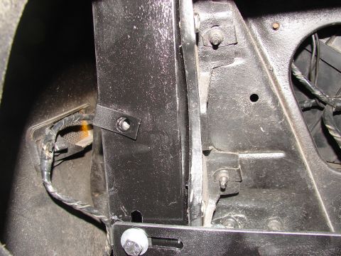 1973 Ford Ranchero - Detail of a mounting bracket and wiring harness within the inner fender well of a vehicle.