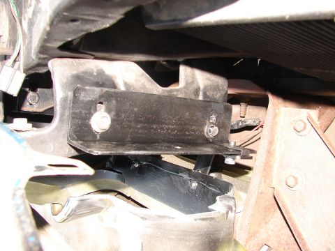 1973 Ford Ranchero - This image shows a close-up view of a vehicle's undercarriage, focusing on a metal bracket and its mounting hardware.