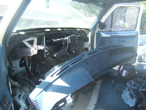 1988 Ford Bronco - The interior of a vehicle is shown with the dashboard removed, revealing its internal components and wiring.