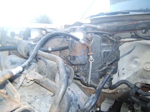 1988 Ford Bronco - Close-up view of engine bay components, including hoses and the AC accumulator.