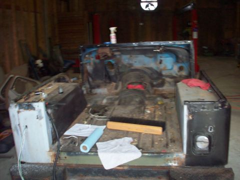 1978 Jeep CJ5 - The rear section of a Jeep CJ is shown disassembled in a garage with tools and cleaning supplies nearby.