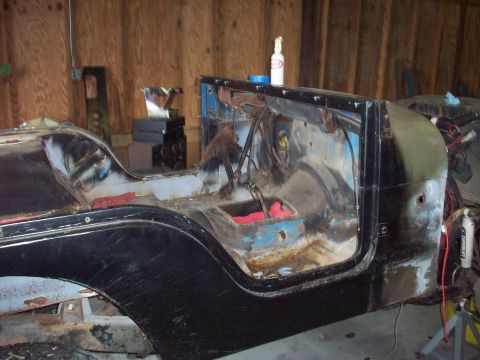 1978 Jeep CJ5 - The body of a disassembled Jeep CJ is shown in a workshop.