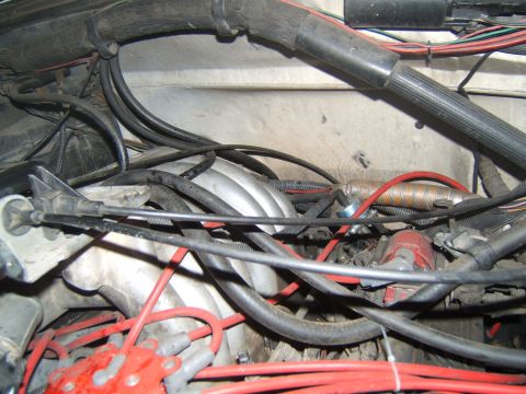1988 Ford Bronco - Close-up view of a cluttered engine bay, showing a distributor cap and wiring harness.
