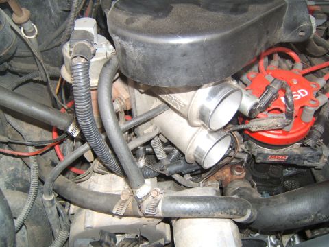 1988 Ford Bronco - Close-up of an engine bay a dual throttle body intake system and a red MSD distributor, suggesting performance modifications.