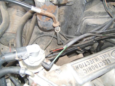 1988 Ford Bronco - Close-up of an engine bay, showing various hoses, wires, and a prominent label indicating 'ELECTRONIC FUEL INJECTION'.