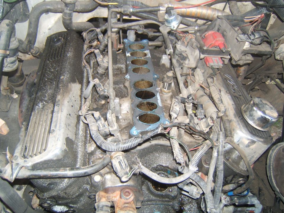 Engine bay showing valve covers, wiring, and intake manifold gasket removed
