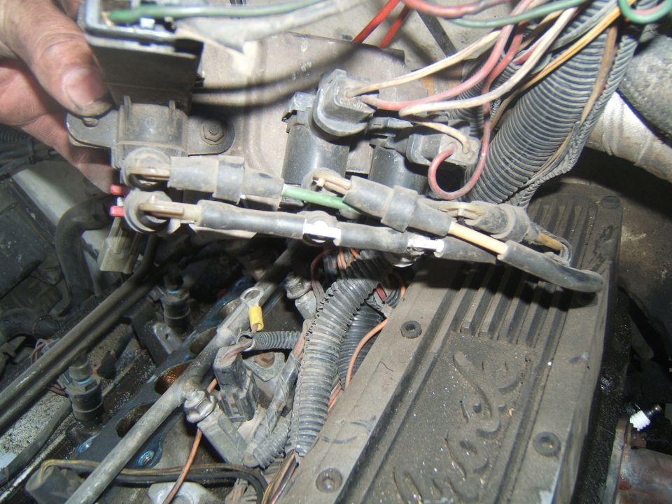 Engine wiring harness connected to fuel injectors and a dirty valve cover