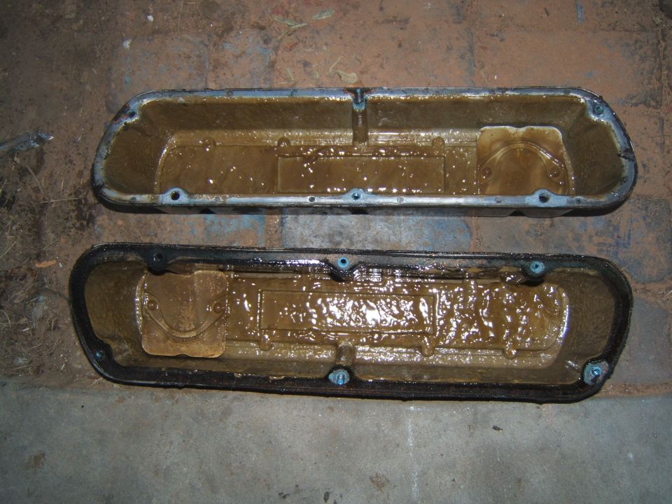 Two engine valve covers filled with brown sludge