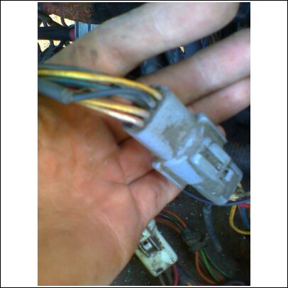 1989 Ford F-150 - Close-up of a vehicle's wiring harness connector being held in a hand.