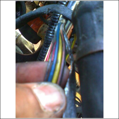 1989 Ford F-150 - A close-up view of a vehicle's wiring harness shows several colored wires, some of which appear damaged.