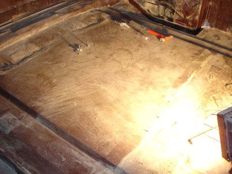 1979 Ford F-250 - The bare metal floor of a vehicle interior, showing signs of wear and some tools laid out.