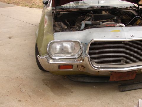 1973 Ford Ranchero - Front view of a 1972 Ford Ranchero with the hood up, revealing the engine compartment and a "CAUTION" sticker.