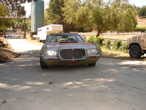 1973 Ford Ranchero - A weathered coupe utility sits in a driveway, with a trailer and another vehicle nearby.