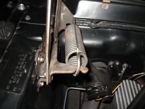 1968 Shelby GT500 - Close-up of the hood spring mechanism on a 1968 Shelby GT500, with a VIN plate visible.