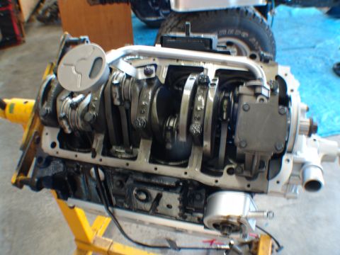 1996 Ford Bronco - The internal components of an engine, including the crankshaft and pistons, are displayed on a yellow engine stand.