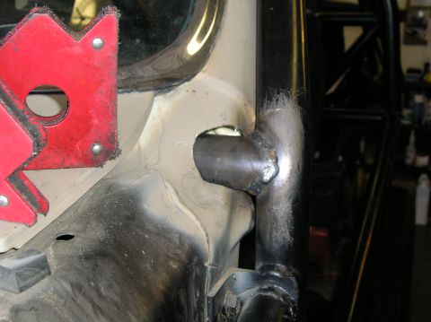 1986 Toyota Hilux - A close-up view shows metalwork and welding on the frame of a vehicle, with a magnetic clamp in place.