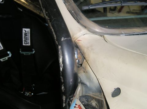 1986 Toyota Hilux - Close-up view of a vehicle's interior, showing a roll cage and a racing seat with safety harness.