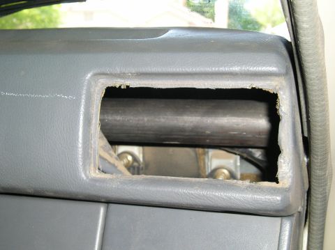 1986 Toyota Hilux - A view of a vehicle's interior dashboard, showing a cut-out section with a metal bar behind it.