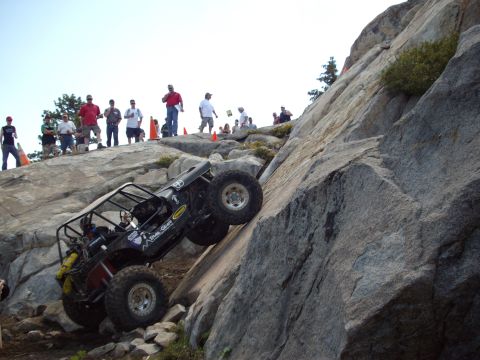 1982 Toyota Pickup/SR5 - An off-road vehicle navigates a challenging rocky incline as onlookers observe the difficult climb.
