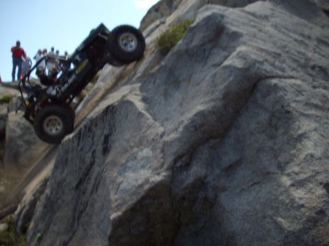 1982 Toyota Pickup/SR5 - An off-road vehicle navigates a challenging rocky incline with onlookers present.