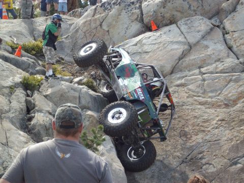 1982 Toyota Pickup/SR5 - A custom off-road buggy navigates a steep, rocky terrain during an event.