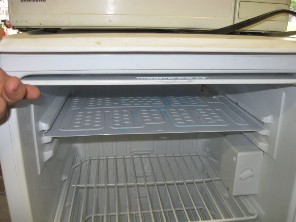 Refrigerator interior with a wire rack and a removable shelf with a grid pattern