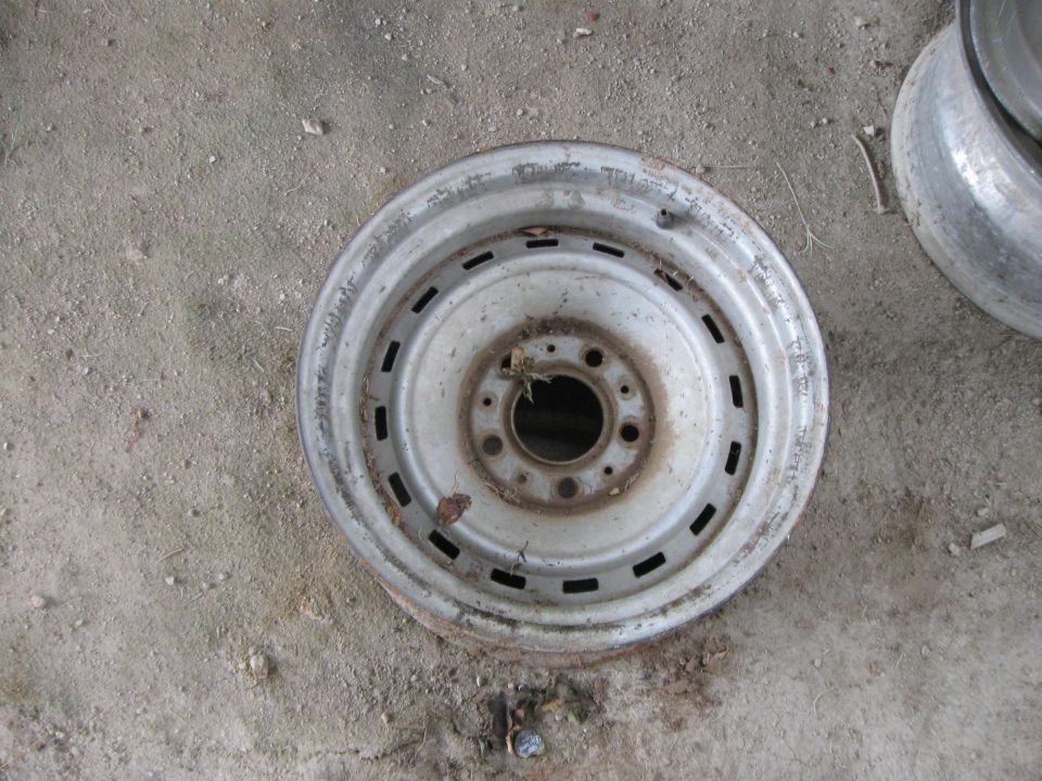 steel wheel rim on dirt ground, another rim visible to the right