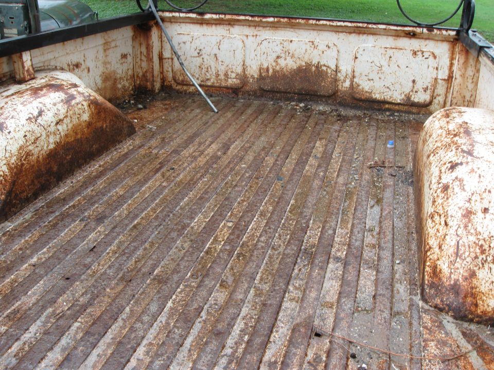 Rusty truck bed with ribbed floor and wheel wells