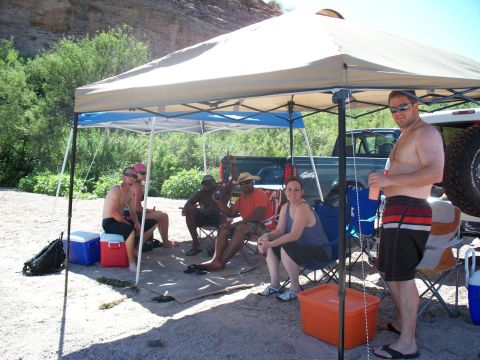 1996 Ford Bronco - People gathered under a canopy at a riverside location on a sunny day.