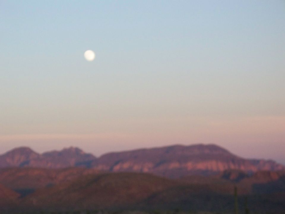 moon over desert mountains at dusk