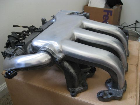 1994 Ford Probe - A polished intake manifold with a black cast iron base is shown, resting on a cardboard box.