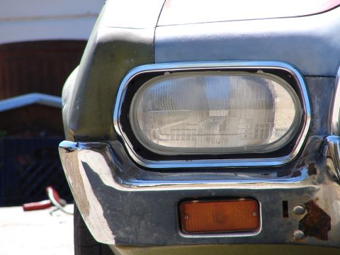 1973 Ford Ranchero - Close-up of the front corner of a 1973 Ford Ranchero, highlighting the headlight and bumper.