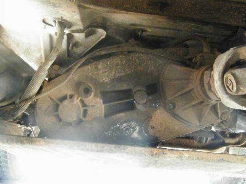 1982 Ford Bronco - Close-up of the vehicle's drivetrain components, showing a transfer case and driveshaft.