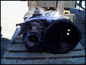1989 Ford Bronco - Transmission assembly, likely for a Ford vehicle, sits on a wooden pallet.