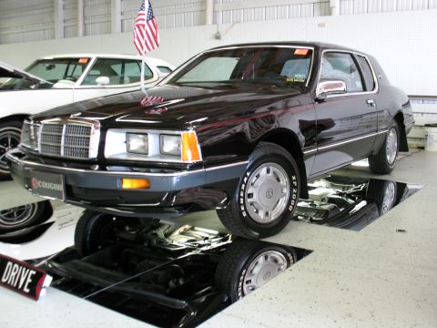 1985 Mercury Cougar - Black 1985 Mercury Cougar displayed in a garage with a vehicle inspection pit.