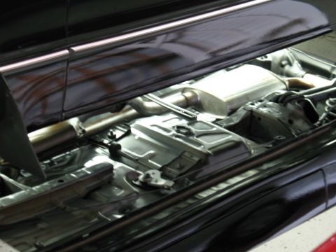 1985 Mercury Cougar - The undercarriage of a vehicle, focusing on the exhaust system and structural components.